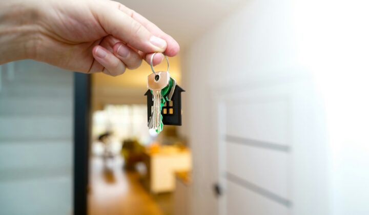 Holding house keys in front of a front door