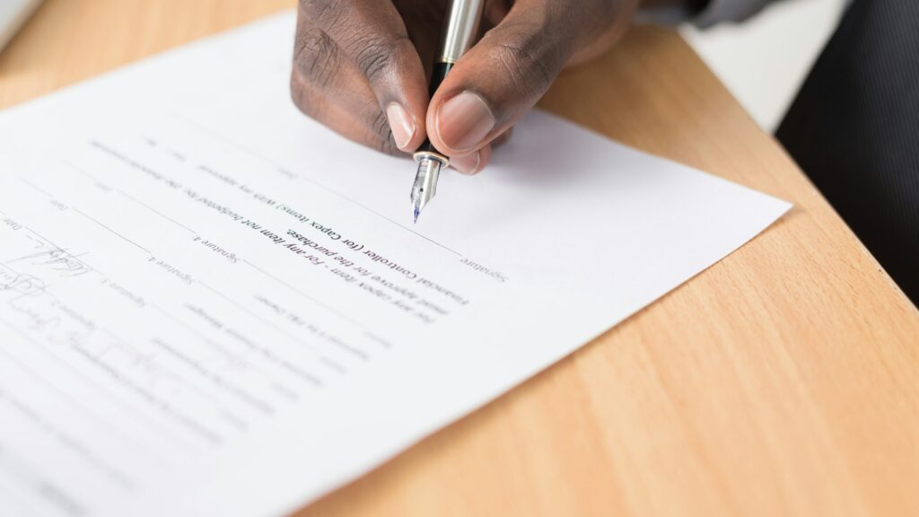 Person writing on a document