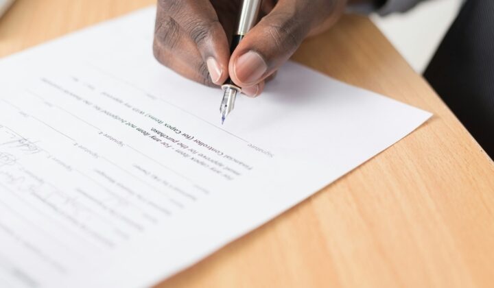 Person writing on a document