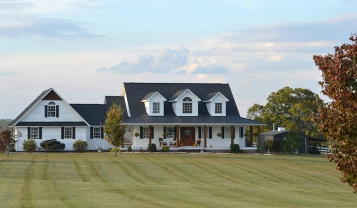 White farmhouse with a wraparound porch in the countryside
